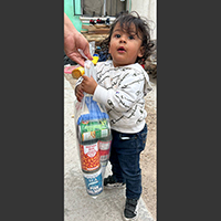 Child holding plastic bag of groceries